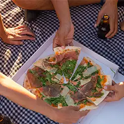 Picnic with friends sharing Prosciutto Arugula Pizza